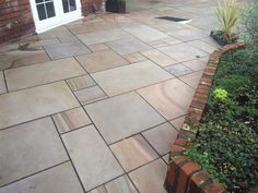 an outdoor patio with brick edging and plants