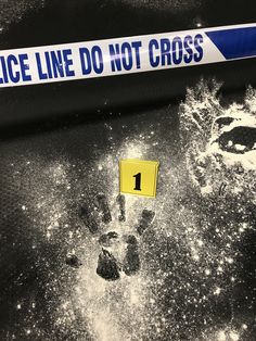 a police line sign and footprints on the ground next to a caution tape that reads 1