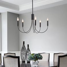 a dining room table with chairs and vases on it