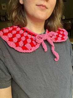 a woman wearing a red and pink crocheted bow