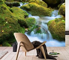 a room with mossy rocks and water flowing down the stream in front of it