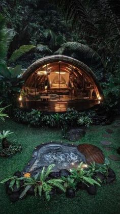 an outdoor hot tub in the middle of a lush green area with trees and plants