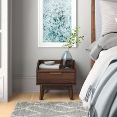 a bed room with a neatly made bed and a painting on the wall above it