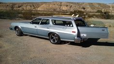 an old car with a surfboard on the top of it's back end