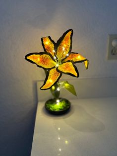 a yellow flower sitting on top of a table