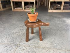 a small wooden stool with a potted plant on it