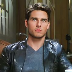 a man in a leather jacket is looking at the camera