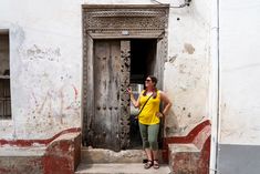 a woman standing in front of an old door