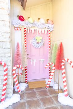 a pink door decorated with candy canes and decorations