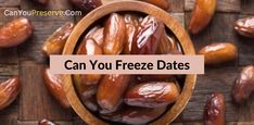 a wooden bowl filled with dates sitting on top of a wooden table next to nuts