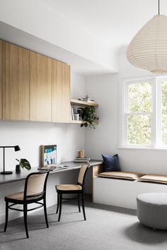 a living room with a couch, table and chair in it next to a window