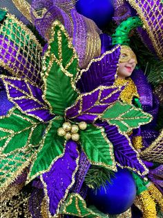 a purple and green christmas wreath with decorations