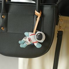 a handbag with a keychain attached to it and a stuffed animal on the front