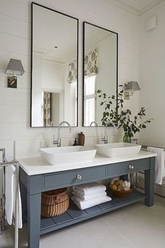 a bathroom with two sinks and mirrors on the wall