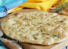 a close up of a pizza on a cutting board near utensils and napkins