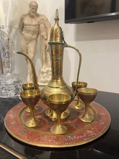 an antique brass tea set sits on a table