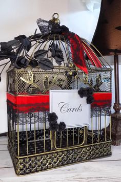 a decorative birdcage with cards attached to it