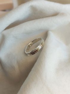 a silver ring sitting on top of a white cloth