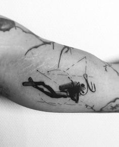 black and white photo of a man's arm with an ink drawing on it