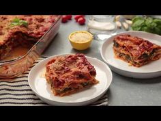 two plates with lasagna casserole on them next to a serving dish