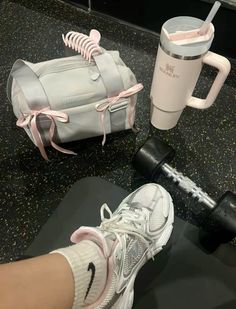 a person's feet on a table next to a gym bag and dumbbells