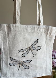 a white bag with two dragonflies on it