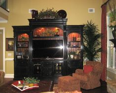 a living room filled with furniture and a flat screen tv on top of a wooden entertainment center