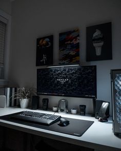 a desk with a keyboard, mouse and two pictures on the wall above it that says vacop