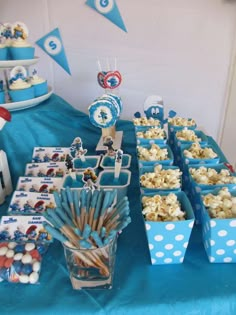 blue and white dessert table set up with cupcakes, marshmallows