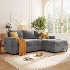 a living room with a gray couch and yellow throw pillows on the floor next to a coffee table