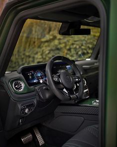 the interior of a green truck with steering wheel and dashboard