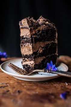 a piece of chocolate cake sitting on top of a white plate next to a fork