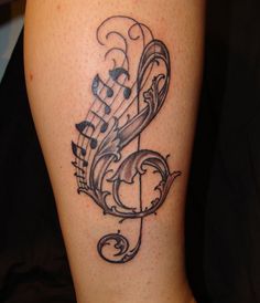 a tattoo with musical notes on it's leg and the word music written in cursive writing