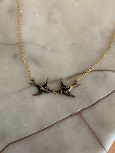 "Two birds in love, how sweet! This design symbolises love and swallows represents \"freedom and everybody is free to find their true love\" The swallows are hand painted black on raw brass measuring 1.8 cm (0.72in) each. The necklace measures 40.6 cm (16 inch) with gold-plated with a 5 cm (2 inch) extender chain. Comes in a black velvet cushioned box as seen in last photo. Free of charge. INTERNATIONAL BUYERS please choose the tracking option if you would like your order to be tracked. FREE tra Wire Tailed Swallow, Gold Necklace With Bird Design As Gift, Gold Swallow Necklace, Swallow Bird Earrings, Birds In Love, Swallow Necklace, Bird-shaped Bird-design Necklace For Gifts, Bird Necklace, Two Birds