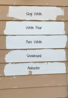 white paint on the side of a house that has four different names painted on it