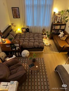 an overhead view of a living room with couches, coffee table and bookshelves