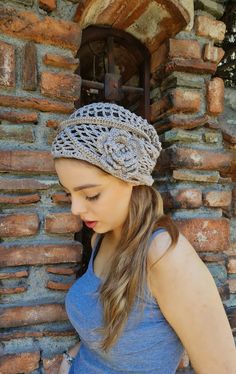 a woman wearing a knitted headband in front of a brick wall and door