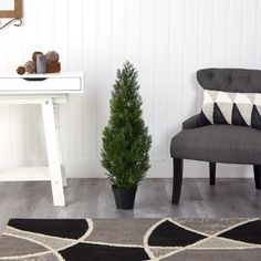 a living room with a chair and a small tree