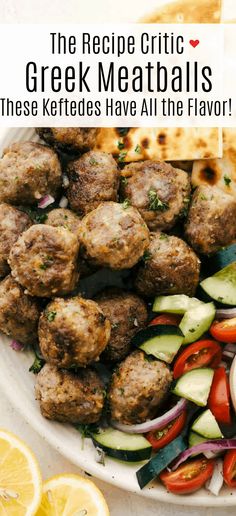 greek meatballs with cucumbers, tomatoes and onions on a white platter