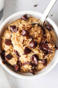 chocolate chip oatmeal in a white bowl with a spoon on the side