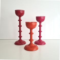 three red candlesticks sitting next to each other