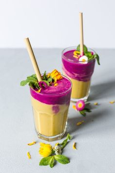 two glasses filled with food and garnish on top of a white tablecloth