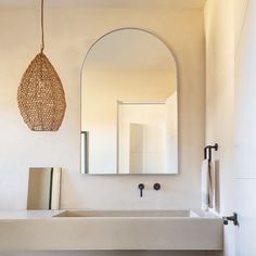 a bathroom sink under a mirror next to a wall mounted faucet and towel rack