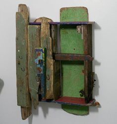 an old wooden box with green paint on the inside and door open to reveal another piece of art