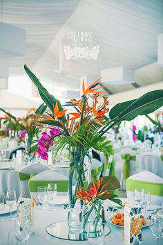 a vase filled with flowers sitting on top of a table covered in white linens