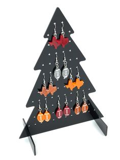 a wooden christmas tree with earrings hanging from it's sides and an ornament on the bottom