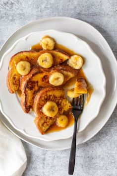 some bananas and syrup on a plate with a fork