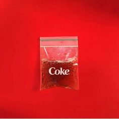 a bag of coke sitting on top of a red refrigerator