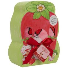 a stuffed strawberry with a red bow on it's head in a green box