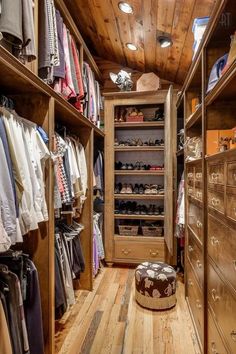 a walk in closet filled with lots of clothes and shoes next to a wooden ceiling